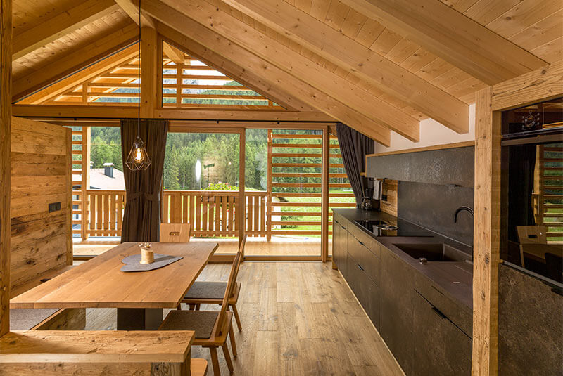 Tavolo da pranzo a sinistra e angolo cottura di colore scuro a destra - Waidacherhof